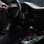 Close-up of a person cleaning a car's dashboard and steering wheel, focused on interior maintenance.